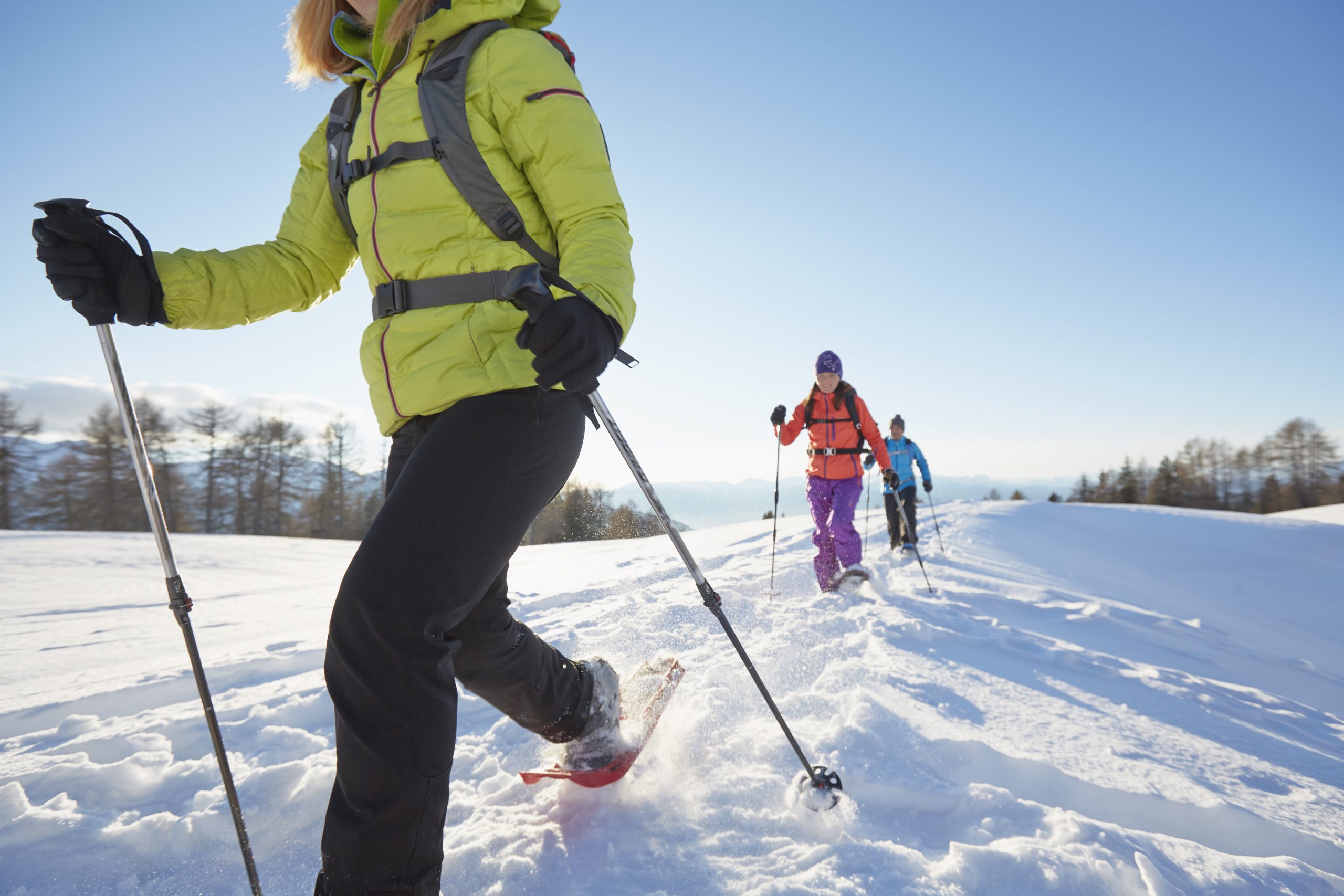 Group snowshoeing in the mountains on a sunny winter day